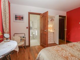 A bedroom with a bed and a connecting bathroom at Stonegarth Cottage Grasmere