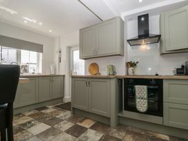 A kitchen with cabinets and appliances at Fountain Cottage in Keswick