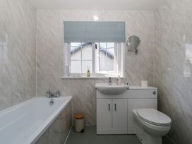 A bathroom with a bath tub, sink, and toilet at Fountain Cottage in Keswick