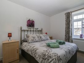 A bedroom with a bed and bedside table at Fountain Cottage in Keswick