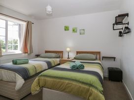 A bedroom with two beds and a lamp at Fountain Cottage in Keswick