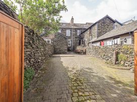 A garden with stone walls and a paved pathway at Ingle Burrow in Windermere