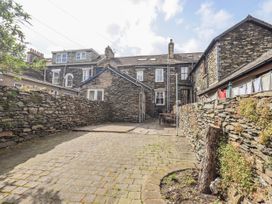 A garden with stone walls and a wooden table at Ingle Burrow Windermere