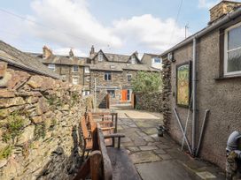 An outdoor area with a stone wall and benches at Ingle Burrow in Windermere