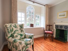 A living room with a patterned chair and fireplace at Little Ellers Portinscale near Keswick
