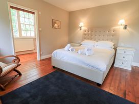 A bedroom with a bed and a rocking chair at Little Ellers in Portinscale near Keswick