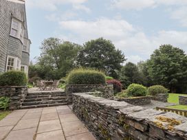 A garden with stone wall and seating area at Little Ellers in Portinscale near Keswick
