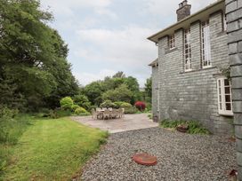 A garden with a table and chairs on a patio at Little Ellers in Portinscale near Keswick