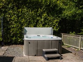 A hot tub with steps beside a fence at The Snug in Longtown