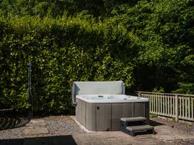 A hot tub with steps in a garden at The Snug Longtown