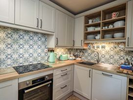 A kitchen with an oven, sink, stove, and kettle at Foresters Cottage in Satterthwaite