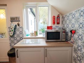 A kitchen with a microwave and fire extinguishers at Foresters Cottage Satterthwaite
