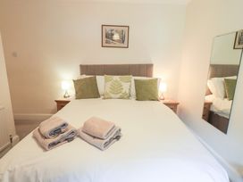 A bedroom with a bed and bedside table at Millcroft in Glenridding