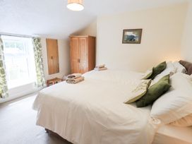 A bedroom with two beds and a dresser at Millcroft in Glenridding