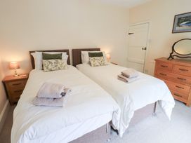 A bedroom with twin beds and a dresser at Millcroft in Glenridding