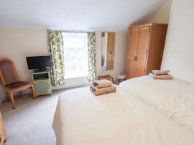 A bedroom with two beds and a television at Millcroft in Glenridding