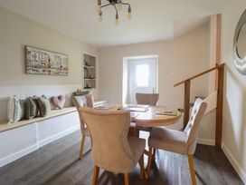 A dining room with a round table and chairs at Cefn Uchaf Cottage in Llanbedr