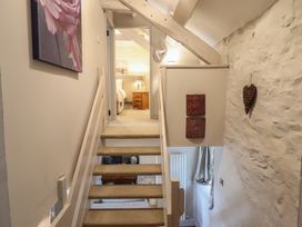 A hallway with stairs and wall art at Cefn Uchaf Cottage in Llanbedr