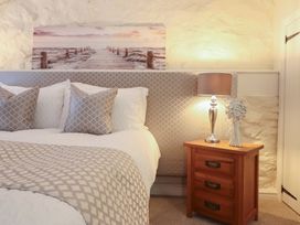 A bedroom with a bed and a bedside table at Cefn Uchaf Cottage Llanbedr