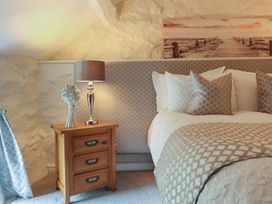 A bedroom with a bed and lamp at Cefn Uchaf Cottage Llanbedr