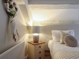 A bedroom with a bed and nightstand at Cefn Uchaf Cottage in Llanbedr