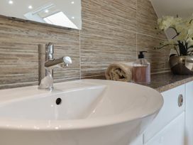 A bathroom sink with a faucet and soap dispenser at Cefn Uchaf Cottage Llanbedr
