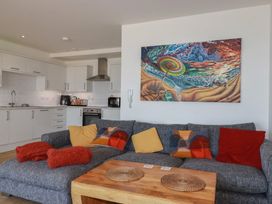 A living room with a sofa and kitchen area at The View in Newquay