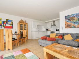 A living room with sofa and dining area at The View in Newquay