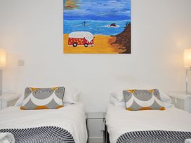 A bedroom with two beds and a painting at The View in Newquay