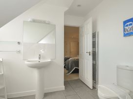 A bathroom with a sink, mirror, and toilet at The View in Newquay