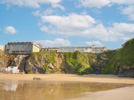 A beach with cliffs and buildings in the background at The View in Newquay