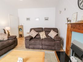 A living room with brown sofas a wooden coffee table and a fireplace at Fairways in Prestatyn