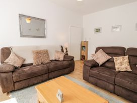 A living room with two brown sofas and a wooden coffee table at Fairways in Prestatyn