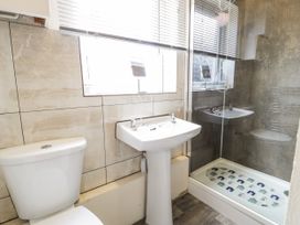 A bathroom with a toilet sink and a glass shower enclosure at Fairways in Prestatyn