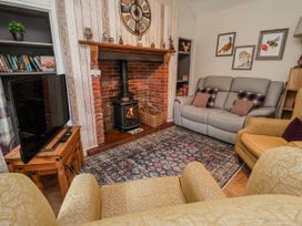 A living room with a television and fireplace at Riverlea in Dyserth