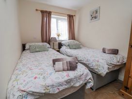 A bedroom with two beds and a window at Riverlea in Dyserth