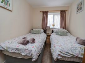 A bedroom with two single beds and a window at Riverlea in Dyserth