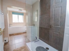 A bathroom with a shower enclosure and bathtub at Riverlea Dyserth