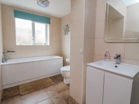 A bathroom with a bathtub, toilet, and sink at Riverlea Dyserth