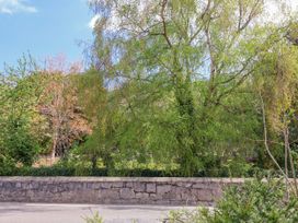 A view of trees and a wall in a garden at Riverlea in Dyserth