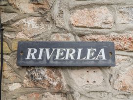 A sign that reads RIVERLEA on a stone wall at Riverlea in Dyserth