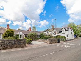 A building with trees and a stone wall near the road at Riverlea Dyserth