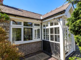 A conservatory with large windows and a door at Ty Cerrig in Dyserth