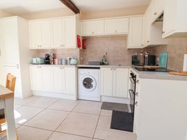A kitchen with cabinets and appliances at Ty Cerrig Dyserth