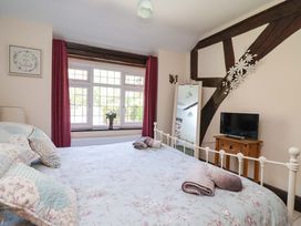 A bedroom with a bed, window, mirror, and tv at Ty Cerrig in Dyserth