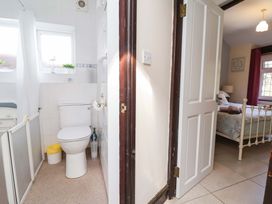 A bathroom with a toilet and a window at Ty Cerrig in Dyserth