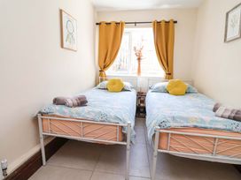 A bedroom with two beds and a window at Ty Cerrig in Dyserth