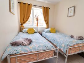 A bedroom with two beds and a window at Ty Cerrig in Dyserth