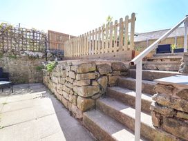 A garden with stone steps and a wooden fence at Ty Cerrig in Dyserth