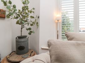 A living room with a plant in a pot beside a lamp at Harriet's Cottage, Briggswath